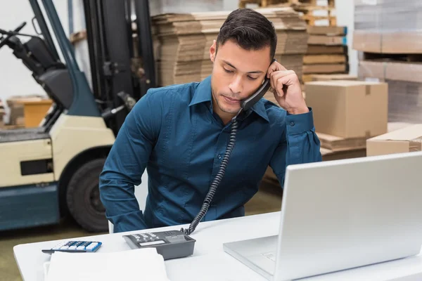 Lagerleiter mit Telefon und Laptop — Stockfoto