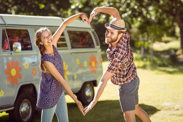 Hipster par att göra hjärtat med armar — Stockfoto