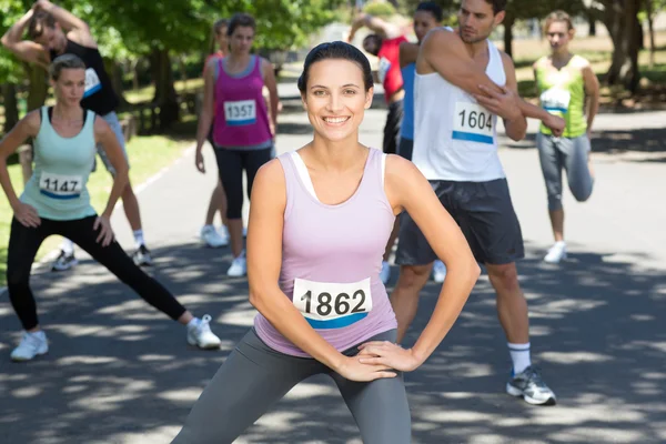 Sorrindo mulher aquecendo antes da corrida — Fotografia de Stock