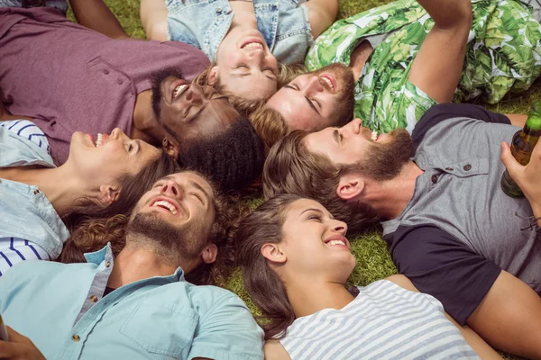 Heureux jeunes amis allongés sur l'herbe — Photo