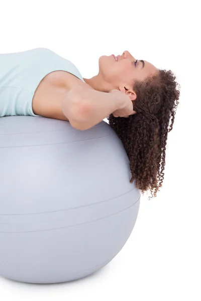 Подходящая женщина делает сидячие упражнения на мяче — стоковое фото