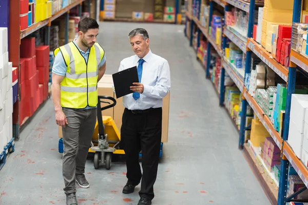 Magazijnmedewerker praten met zijn manager — Stockfoto