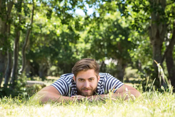 Hipster lying on the grass in the park — Stock Photo, Image