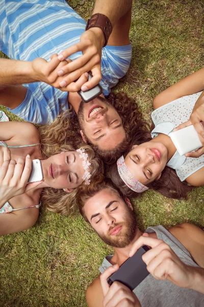 Hipsters lying on grass smiling — Stock Photo, Image