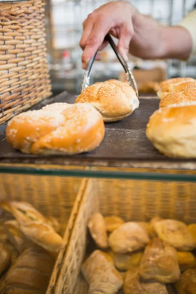 Kellnerhand nimmt Brot mit der Zange — Stockfoto