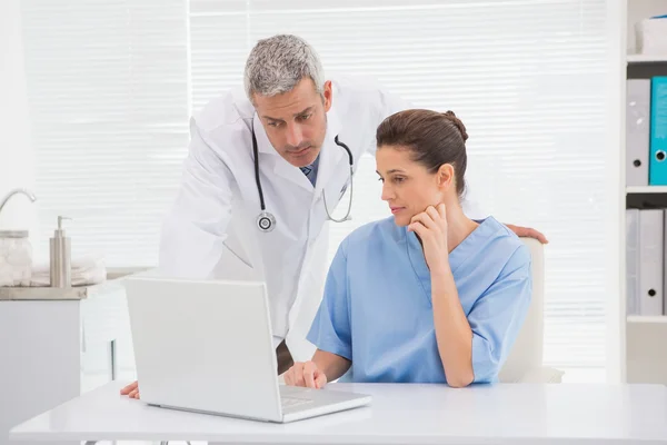 Los médicos mirando a la computadora portátil — Foto de Stock