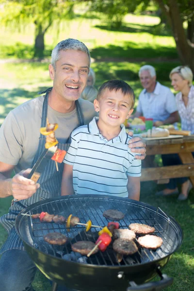 Pai feliz fazendo churrasco com seu filho — Fotografia de Stock