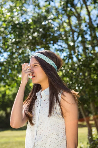 Pretty brunette using her inhaler — Stock Photo, Image