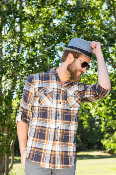 Guapo hipster sonriendo en el parque —  Fotos de Stock