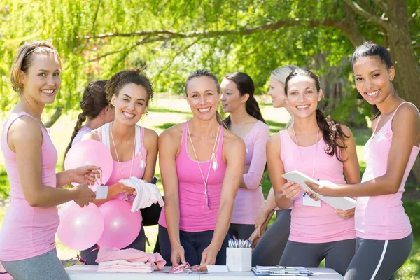 Smiling women organising event for breast cancer awareness — Stock Photo, Image