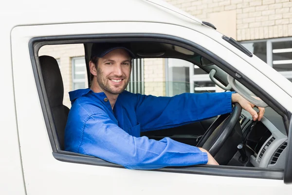 Lieferfahrer lächelt in seinem Lieferwagen in die Kamera — Stockfoto