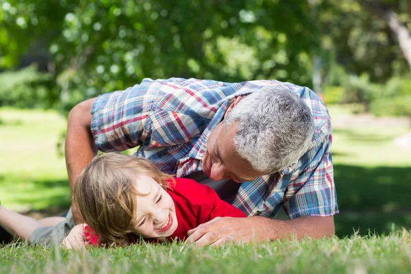 Padre jugando en la hierba con su hijo — Foto de Stock