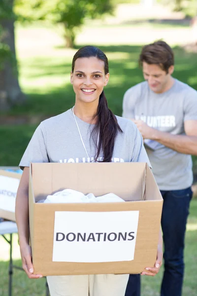 Voluntaria morena sosteniendo caja de donación — Foto de Stock