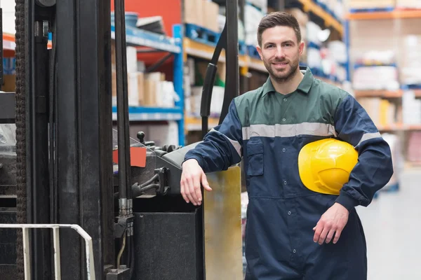 Arbeiter lehnt sich an den Gabelstapler — Stockfoto