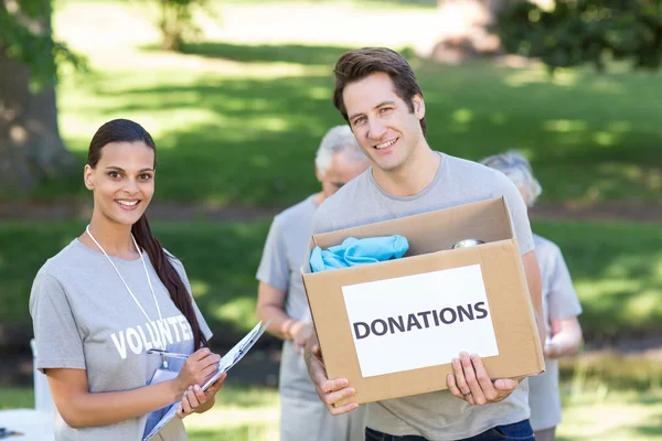 Feliz voluntario sosteniendo caja de donación — Foto de Stock