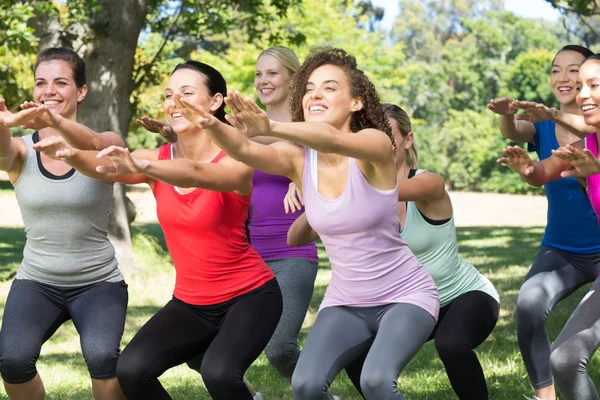 Fitness grupp hukande i park — Stockfoto