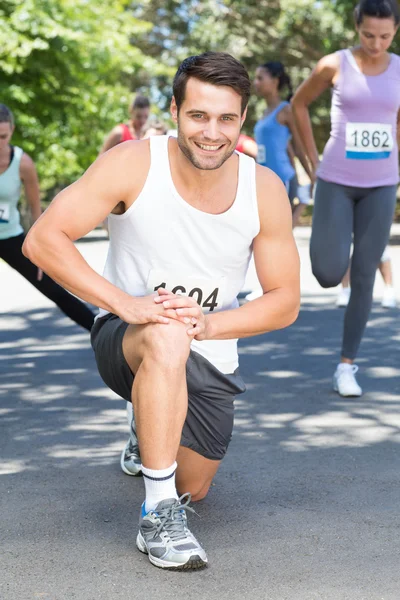 Sorrindo homem aquecendo antes da corrida — Fotografia de Stock