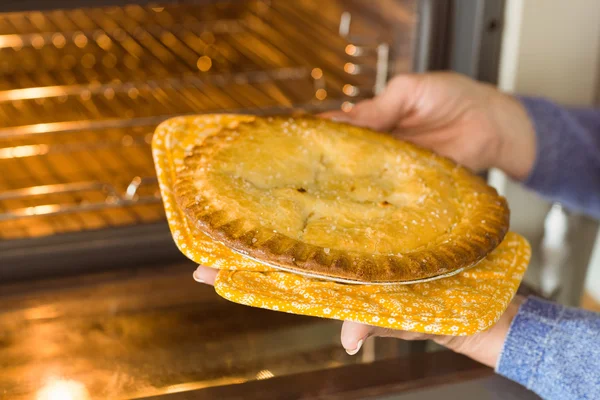 Wanita mengambil pie segar keluar dari oven — Stok Foto