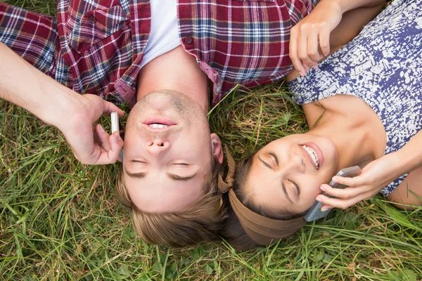 Par avkopplande i parken på telefoner — Stockfoto