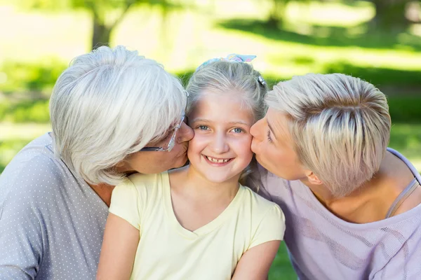 Happy family kissing little girl — Stock Photo, Image