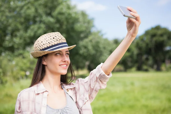 Brunette taking a selfie in park — Stock Photo, Image