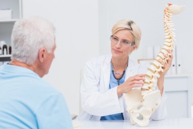 Doctor explaning anatomical spine to patient clipart