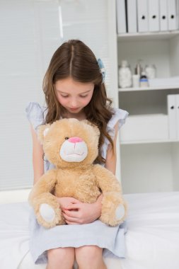 Girl with teddy bear in her harms clipart