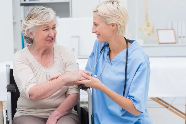 Verpleegkundige controleren flexibiliteit van patiënten pols — Stockfoto