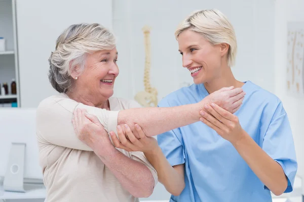 Медсестра помогает пациенту поднять руку — стоковое фото