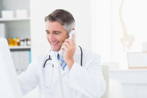 Médico masculino usando telefone fixo — Fotografia de Stock