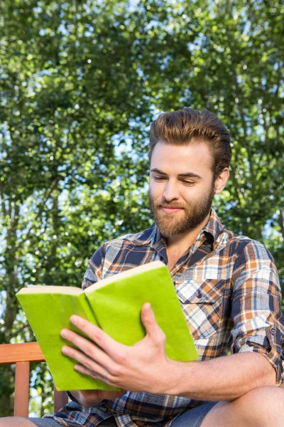 Knappe hipster lezen in het park — Stockfoto