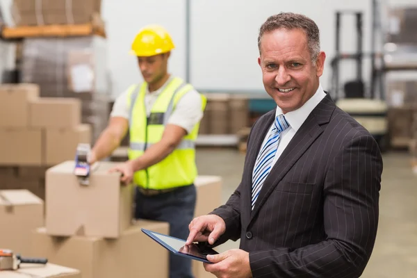 Boss using digital tablet in warehouse — Stock Photo, Image