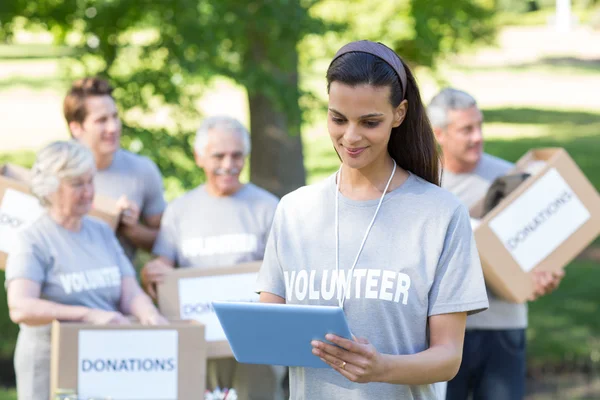 Volunteer brunette using tablet pc — Stock Photo, Image