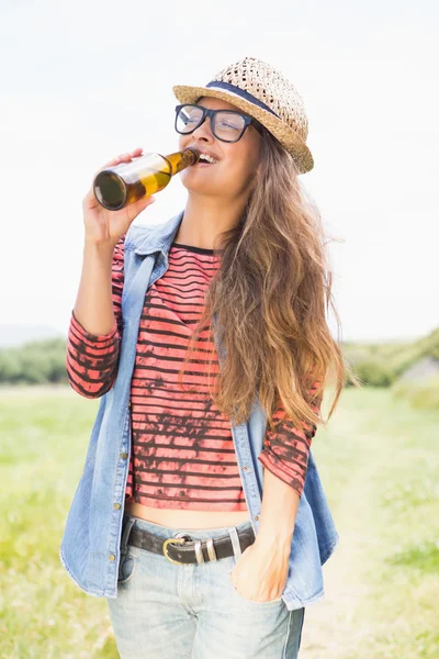 Brunette in the park drinking beer — Stock Photo, Image