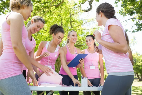 Smiling women organising event for breast cancer awareness — Stock Photo, Image