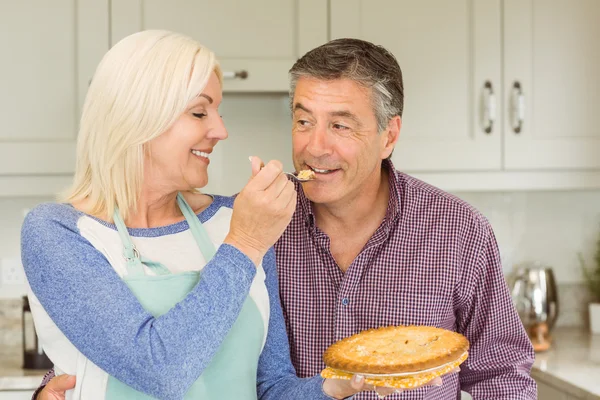 Зріла блондинка годує пиріг чоловікові — стокове фото