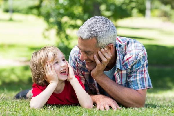 Ojciec, leżąc na trawie z synem — Zdjęcie stockowe