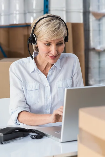 Smiling warehouse manager using laptop — Stock Photo, Image