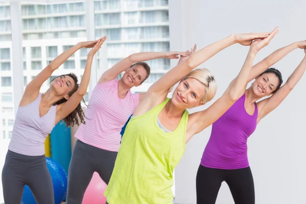 Mujeres practicando ejercicio de estiramiento en el gimnasio —  Fotos de Stock