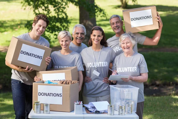 Voluntarios familia sosteniendo cajas de donaciones —  Fotos de Stock