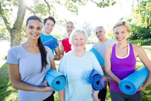 Happy athletic group holding mat — Stock Photo, Image