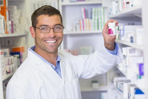 Bonito farmacêutico segurando frasco de medicina — Fotografia de Stock