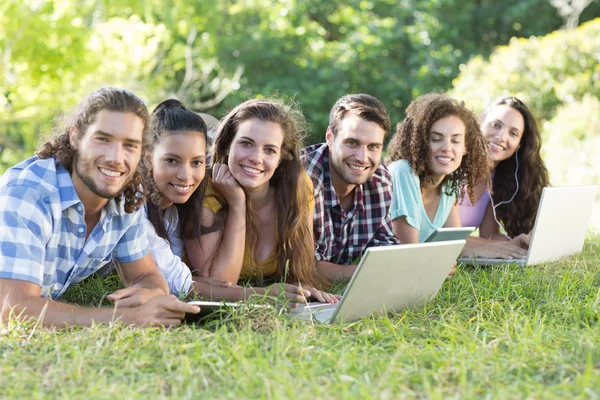 Amigos sonrientes en el parque usando tableta PC y portátil — Foto de Stock