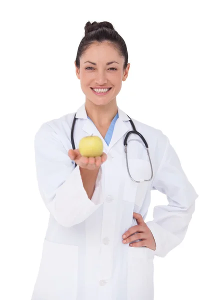 Médico sorrindo oferecendo uma maçã — Fotografia de Stock