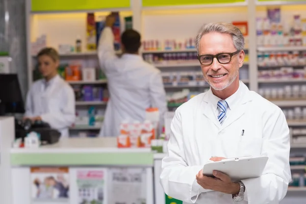 Senior farmaceut ler mot kameran — Stockfoto