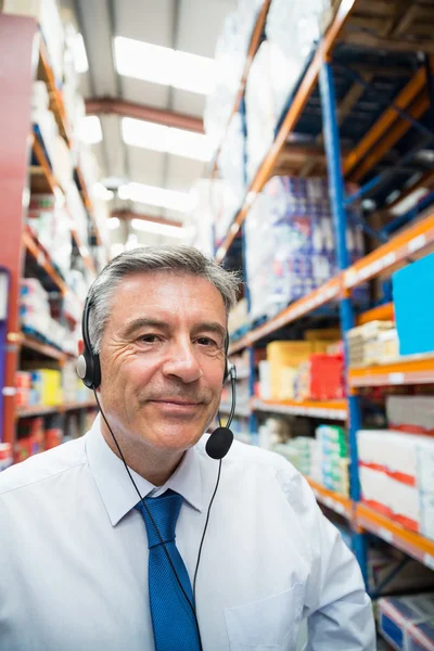 Magazijnbeheerder geven bestellingen op headset — Stockfoto