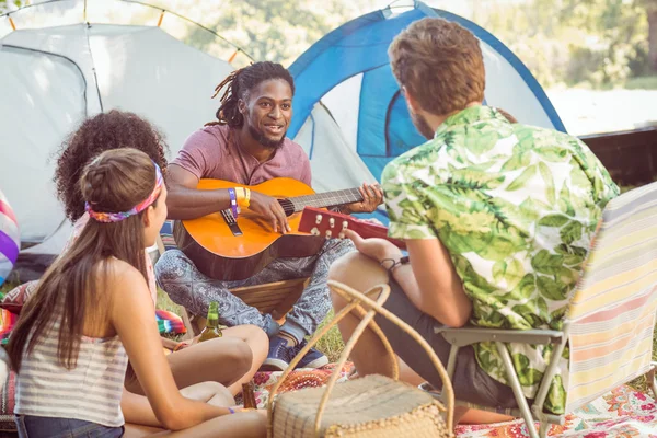 Hipster tocando guitarra para seus amigos — Fotografia de Stock