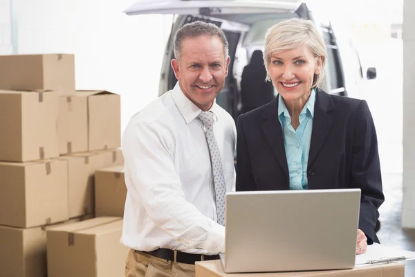 Colleague with laptop at warehouse — Stock Photo, Image