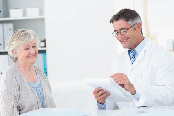 Doctor writing prescriptions for senior patient — Stock Photo, Image