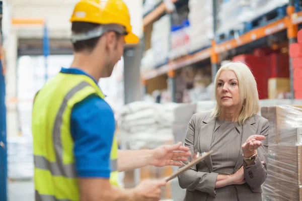 Worker with clipboard speaking with his manager — Stock Photo, Image
